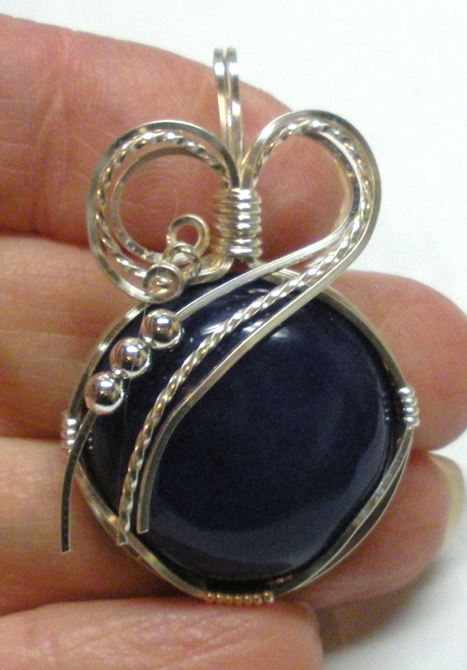 Judy Larson's Sweetheart Pendant - , Classic Wire Jewelry, Wire Wrapping, Wrapping, Wire Wrapping Jewelry, Make a curved sweep over the top of the cabochon with the wires from the right side.